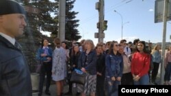 Миләүшә Хәбетдинова (уртада) студентлар белән Тукай һәйкәленә чәчәк салу чарасына кертелми тора