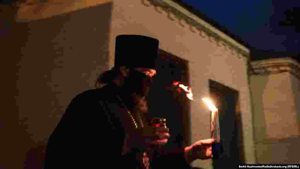 Благодатний вогонь священники роздавали людям. Намісник Воскресенської церкви Сергій Ющик несе вогонь до людей