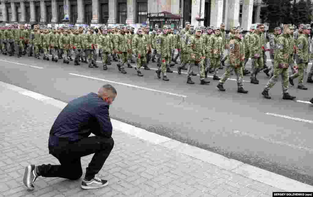 Чоловік став на коліно перед учасниками Маршу пам&#39;яті полеглих захисників України у війні з Росією на Донбасі. Київ, Хрещатик, 8 травня 2019 року