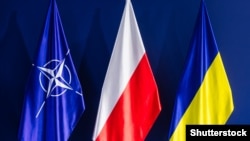 The flags of NATO, Poland, and Ukraine. Poland, the largest country on NATO's eastern flank, finds itself increasingly targeted by Moscow's intelligence services as Russia's invasion of Ukraine continues.