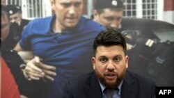 Леонид Волков на фона на кадри с Алкесей Навални. Снимката е от 14 декември 2021 г.