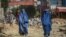 Burqa-clad Afghan women walk past a construction site in Kabul on September 8.