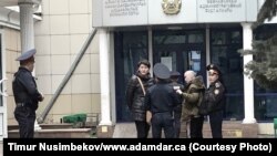 Активисты Асия Тулесова (в центре слева) и Бейбарыс Толымбеков (третий слева) у здания суда перед началом разбирательства, Алматы, 21 апреля 2019 года.