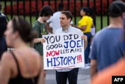 Bir adam Waşingtondaky Ak tamyň öňünde Pensilwaniýa-awende ABŞ-nyň prezidenti Jo Baýdenden minnetdarlygyny bildirýän ýazgyny saklaýar, Kolumbiýa okrugy, 2024-nji ýylyň 21-nji iýuly.