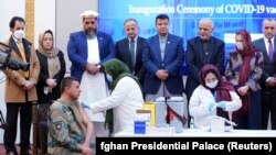 A member of the Afghan security forces receives the first dose of AstraZeneca's COVID-19 vaccine from India during a ceremony at the presidential palace in Kabul on February 23.
