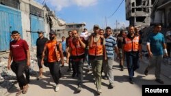 کشته شدن یکی از اعضای دفاع مدنی فلسطینی پس از حمله شبانهٔ اسرائیل به یک پناهگاه آوارگان در محله زیتون در شهر غزه