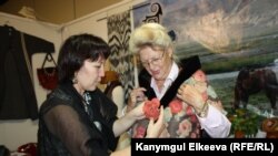 Асел Темиралиева Берлиндеги "Базар" эл аралык жармаңкеде кардар менен.