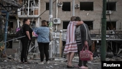 Residents observe the damage to an apartment building in Zaporizhzhya after a Russian air attack on August 30.