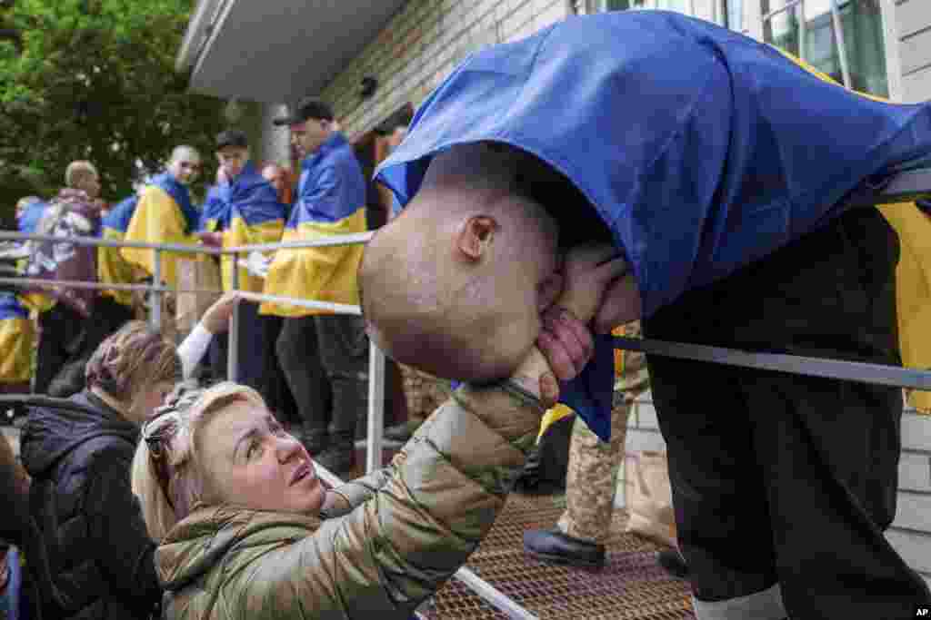 یک سرباز اوکراینی پس از بازگشت از اسارت در تبادل اسرا بین روسیه و اوکراین در ششم مه، دست زنی را می‌بوسد