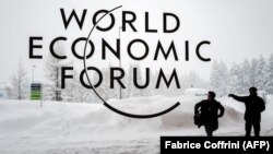 SWITZERLAND -- A security guard show the way to a man outside of the Davos Congress Centre under snow ahead of the opening of the World Economic Forum (WEF) 2018 annual meeting, in Davos, January 22, 2018