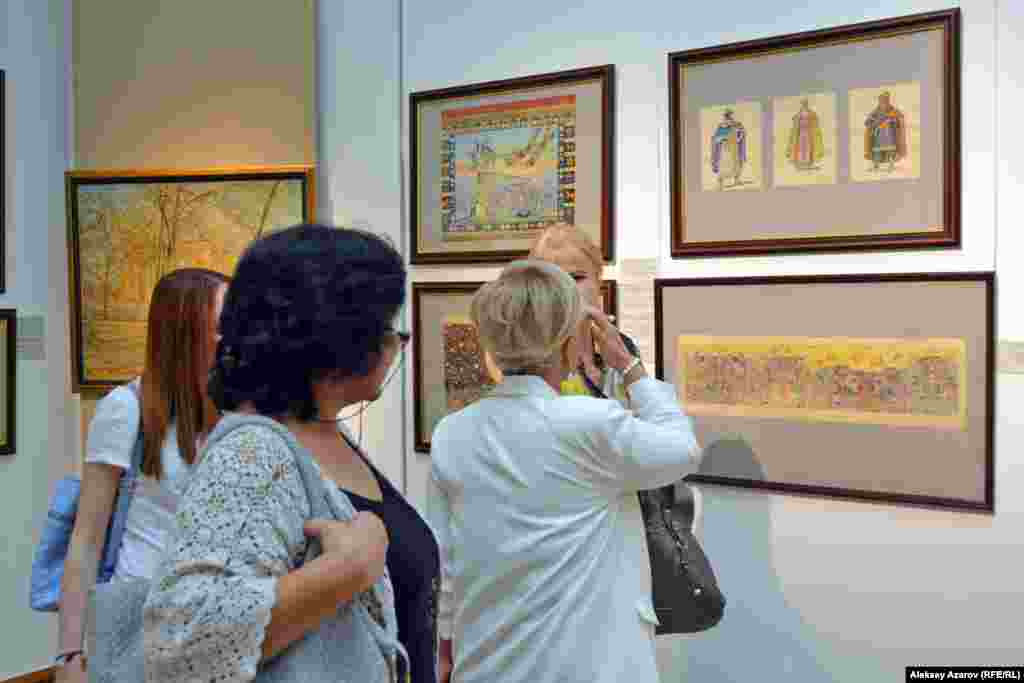 С самого переезда в Алма-Ату в 1935 году до выхода на пенсию Сергей Калмыков работал художником в Театре оперы и балета имени Абая. За это время он создал большое количество театральных декораций и иллюстраций к спектаклям. На выставке представлена и эта часть творчества Сергея Калмыкова. Посетительницы перед эскизами декораций к спектаклям, иллюстрациями театральных персонажей.