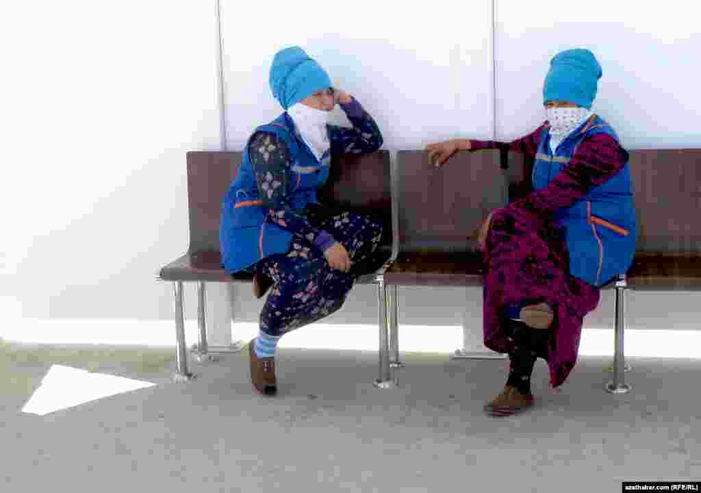 Duragla oturgyjynda saýalap hem dynç alyp oturan iki işçi zenan