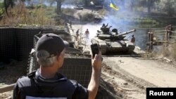 Представник ОБСЄ спостерігає за відведенням українських танків у рамках домовленостей про відведення від лінії зіткнення озброєння калібром до 100 мм. Селище Нижнє, Луганська область, 5 жовтня 2015 року