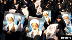 تصاویر عیسی قاسم در دست هواداران بحرینی‌اش.