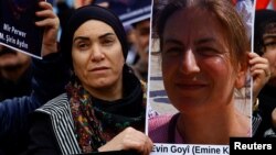 تصویر یکی از کشته‌شدگان حمله به مرکز کردها در پاریس در دستان یکی از تجمع‌کنندگان در میدان رپوبلیک پاریس، ۲۴ دسامبر ۲۰۲۲