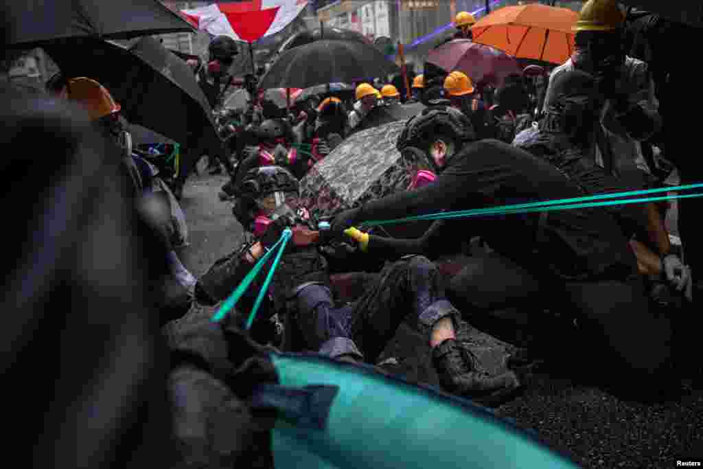Протестующие используют рогатки против спецназа, Гонконг, 25 августа 2019 года.