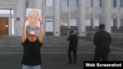 Қытайда ұсталған Тұрғанбай Әлімнұрдың қызы Риза Әлімнұр әкімдік алдында әкесінің суретін ұстап тұр. Алматы, 29 тамыз 2025 жыл.