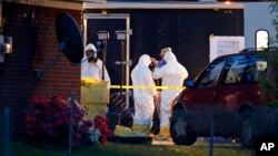 Работники ФБР в костюмах химической защиты осматривают дом после серии рициновых отравлений. Тупело, Миссисипи, 23 апреля 2013 года.