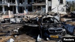 Згорілі автомобілі та пошкоджена будівля на місці падіння ракетного удару Ірану по Ізраїлю в Беер-Шеві, Ізраїль, 20 червня 2025 року