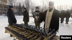 Православный священник освящает винтовки для белорусских новобранцев