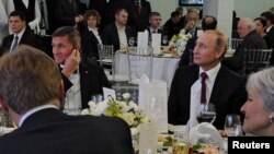 Russian President Vladimir Putin (right) sits next to retired U.S. Army Lieutenant General Michael Flynn at a Russia Today dinner in 2015.
