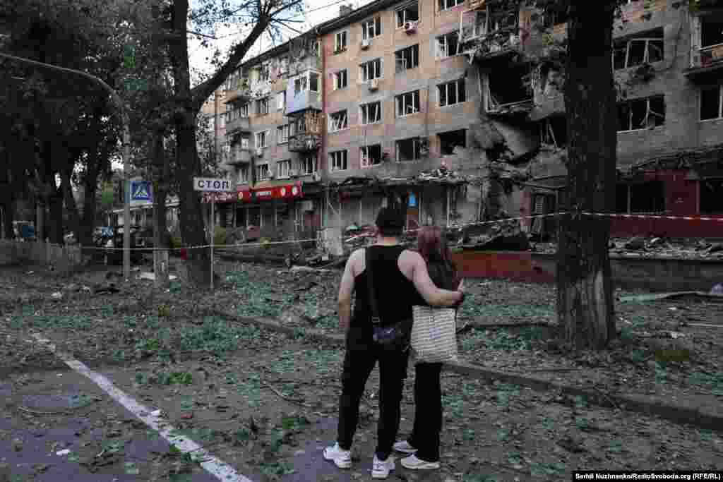 Кияни дивляться на пошкоджений внаслідок російської повітряної атаки будинок. Ранок 4 липня 2025 року