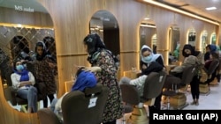 Косметологи делают макияж клиентам в салоне красоты в Кабуле в апреле 2021 года. Талибы после прихода к власти закрыли салоны красоты