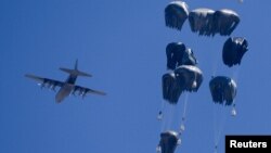 Газага азык-түлүк жана дары-дармек парашют аркылуу түшүрүлүп жатат.