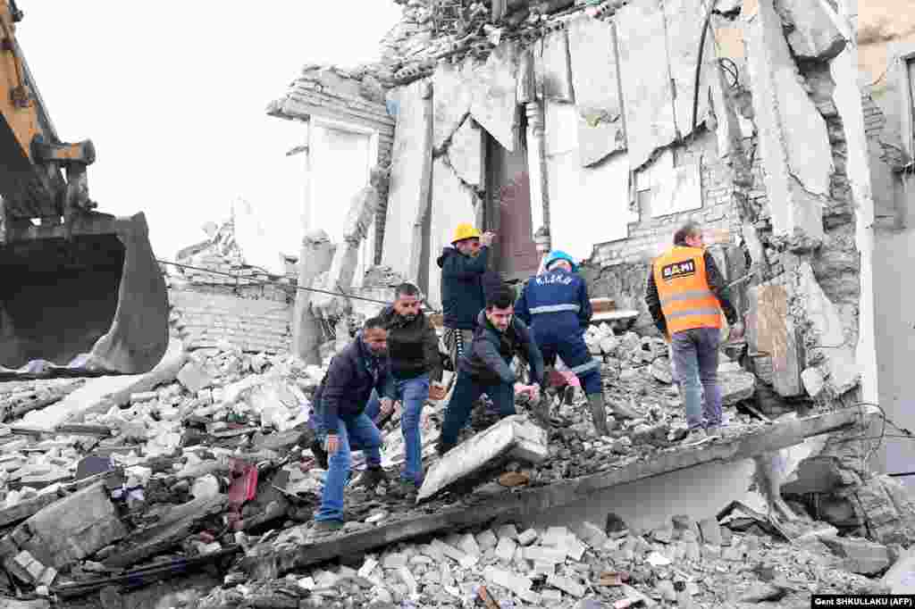 Emergency workers clear debris at a damaged building in Thumane, 34 kilometers northwest of the capital, Tirana.