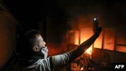 یک عراقی در حال گرفتن سلفی در ساختمان کنسولگری ایران در بصره .