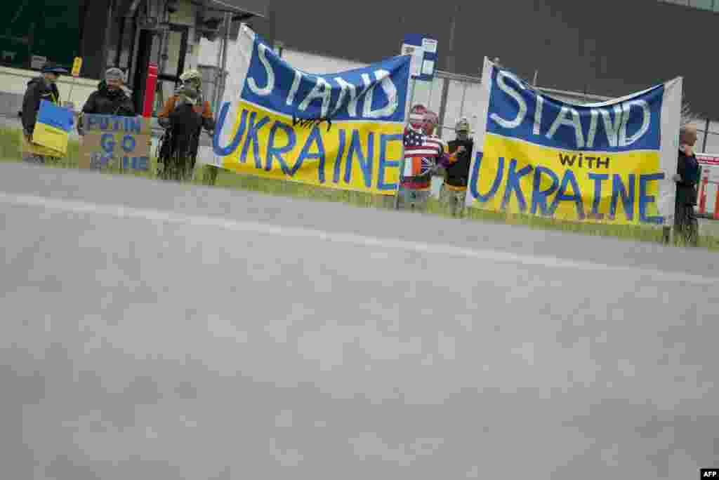 Протестувальники тримають українські прапори та банери з написами: «Підтримай Україну» та «Путін, йди додому» біля бази «Елмендорф-Річардсон» під час зустрічі президента США Дональда Трампа та президента Росії Володимира Путіна в Анкориджі, Аляска, 15 серпня 2025 року