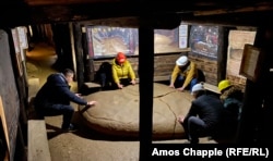 Гид (слева) предлагает туристам почувствовать исходящую от камня «энергию». По словам Османагича, этот камень — керамическая плита искусственного происхождения, найденная в туннелях Високо.