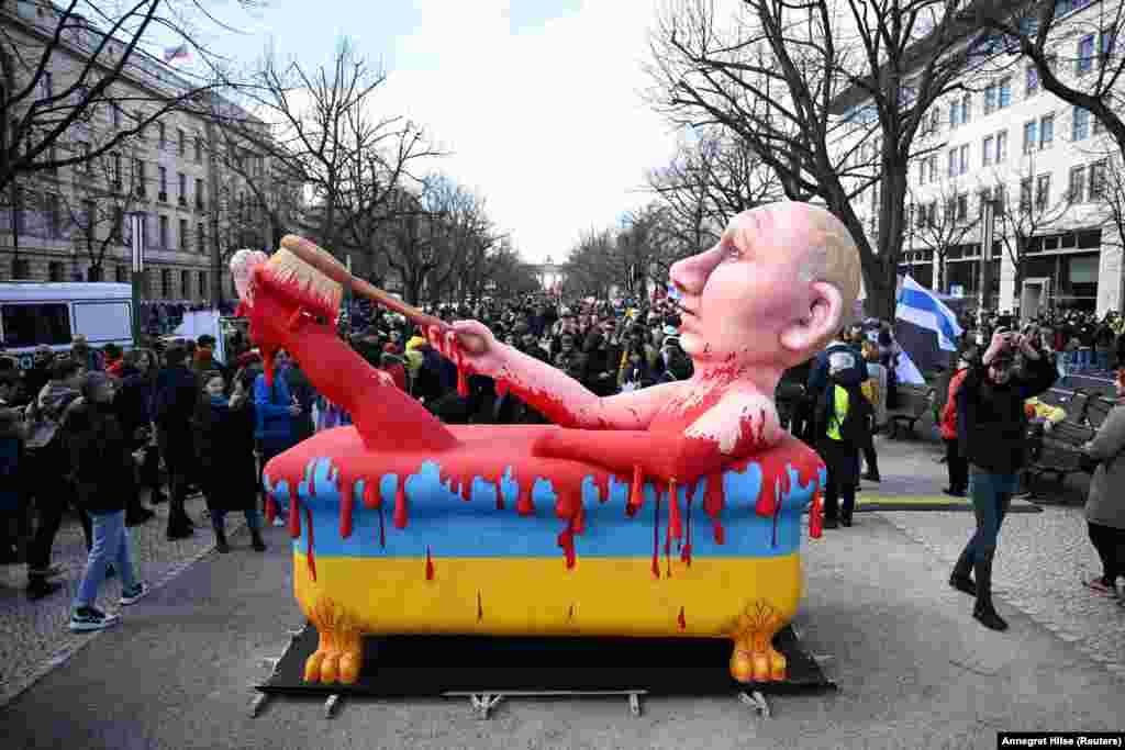 تصویری از پوتین، در مارس ۲۰۲۴، که در مقابل سفارت روسیه در برلین در خون اوکراینی‌ها حمام می‌کند.