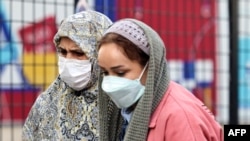 Жени носат маски за да се заштитат од загадувањето на воздухот во Техеран на 29 ноември