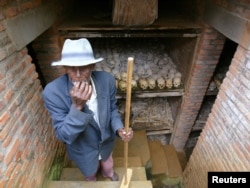 مردی در حال تمیز کردن گوری دست جمعی در رواندا