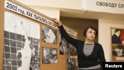 Оксана Макушина, заместитель редактора газеты "Голос республики", показывает на фотографии обезглавленной собаки, подвешенной на двери офиса редакции. Алматы, 21 ноября 2012 года.