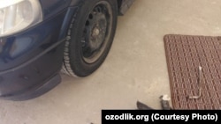 Тожикистон фуқароси машинаси ғилдирагини ечмоқда