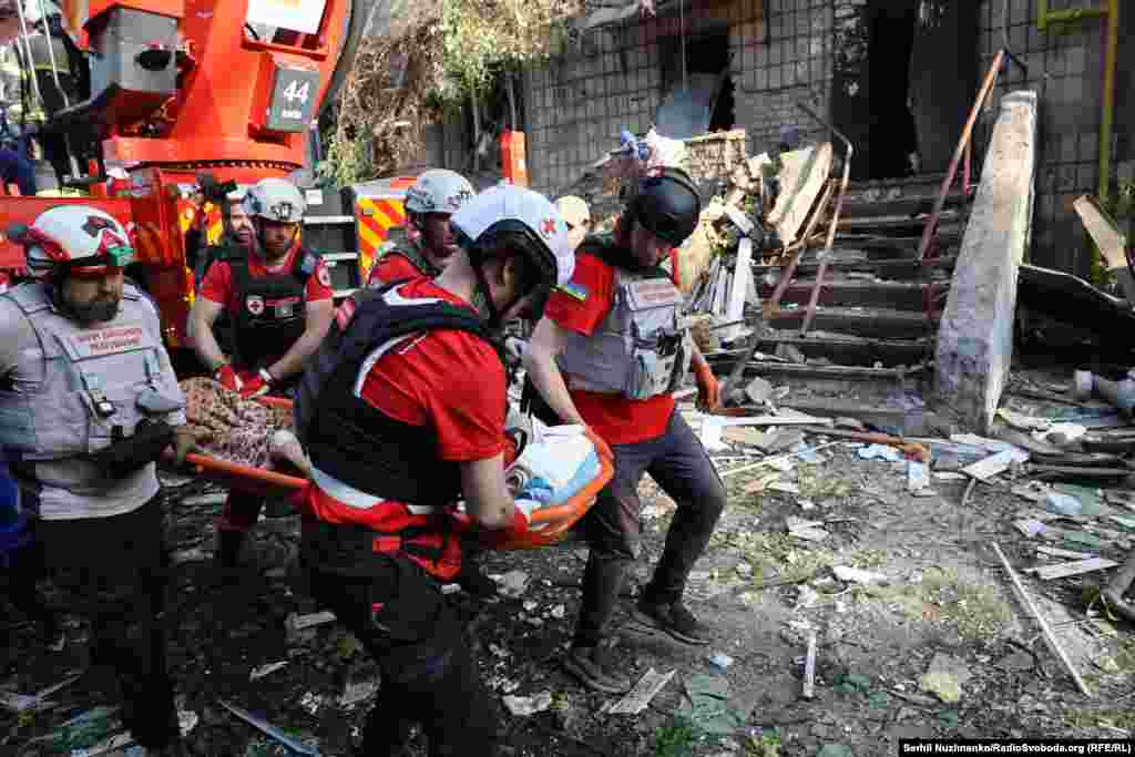 Ратаўнікі эвакууюць параненага ў адным з раёнаў Кіева.