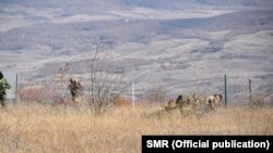 Несколько российских военных с утра приступили к монтажу новых ограждений