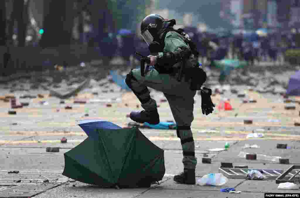 18 ноябрьдә Һонг Конгтагы политехник университет янында полиция демократия яклы демонстрациячеләр белән бәрелеш вакытында аларның кулчатырларын таптый. (EPA-EFE/Fazry Ismail)