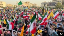 Etirazçılar Tehranda ABŞ və İsrail əleyhinə şüarları səsləndirərkən İran bayraqları və Ali rəhbər Əli Xameneinin plakatlarını qaldırırlar. 24 iyun 2025