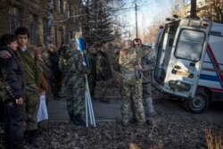 Родичі чотирьох загиблих біля Дебальцевого бійців і члени військово-медичної команди втішають одне одного, лютий 2015 року