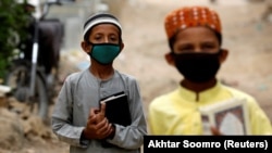 Boys wearing protective masks head to the madrasah in Karachi in July.