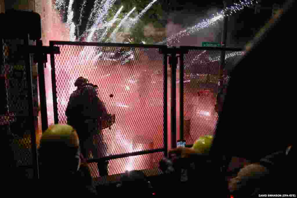 Американські федеральні агенти та місцева поліція охороняють Центр правосуддя під час сутичок з протестувальниками Black Lives Matter у центрі міста Портленд. 25 липня 2020 року