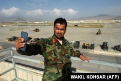 یکی از نیروهای ارتش افغانستان در حال گرفتن سلفی، اندکی پس از خروج نیروهای آمریکایی از پایگاه بگرام