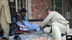 People attend to a man injured in a blast in the Afghanistan's Balkh Province on March 11.