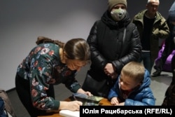 Авторка підписує книгу родині одного з бійців