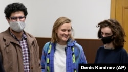 Doxa magazine editors Armen Aramyan (left to right), Natalya Tyshkevich, and Alla Gutnikova wait for a court session in Moscow in April 2021.