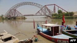 Чоловік йде вздовж річки Інд біля свого човна біля мосту Лансдаун у Суккурі, у південній провінції Сінд, Пакистан, 28 квітня 2025 року