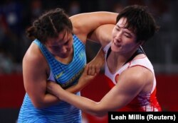 Поединок Айпери Медет кызы ( в бело-красной форме) и казахстанки Элмиры Сыздыковой, Токио, 1 августа 2021 г.